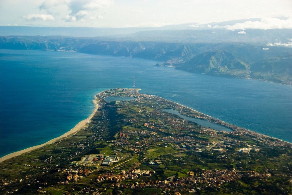 Veduta aerea di Capo Peloro, il punto più a nord-est della Sicilia, con lo Stretto di Messina e le coste della Calabria sullo sfondo.